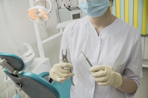 Tandarts houden van een apparaat voor operatie close-up. Doctor in de stomatologie — Stockfoto