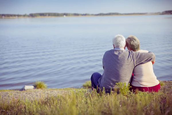 Adultos casal idosos na costa do lago — Fotografia de Stock