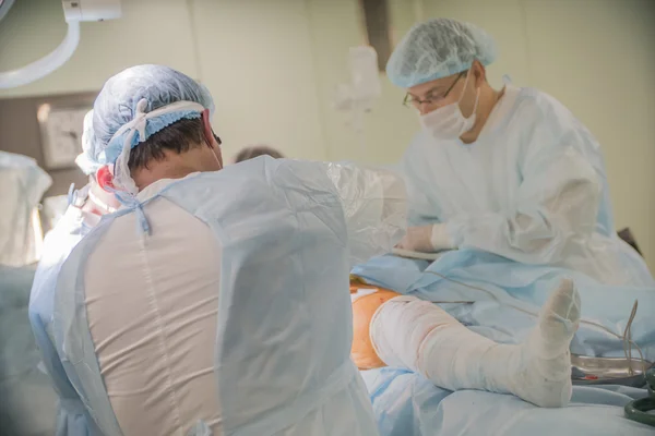 CHELYABINSK, RUSIA - 19 de junio de 2016: primer plano de un pie con el vendaje del paciente a la cirugía en el cuello del fémur en el quirófano de un hospital — Foto de Stock