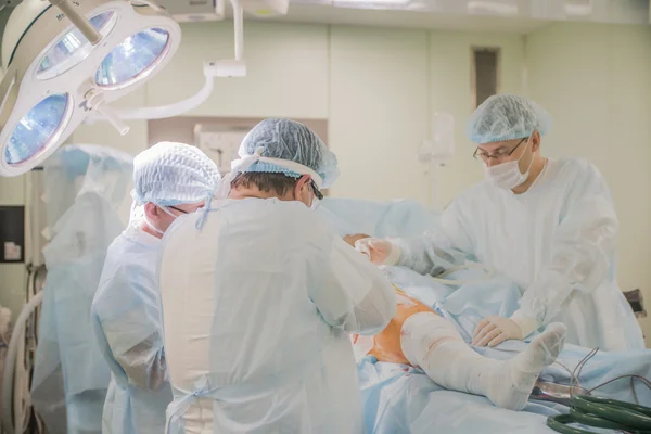 CHELYABINSK, RUSIA - 19 de junio de 2016: primer plano de un pie con el vendaje del paciente a la cirugía en el cuello del fémur en el quirófano de un hospital — Foto de Stock