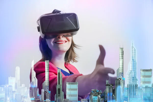 Femme vêtue de lunettes modèle de réalité virtuelle regarde les gratte-ciel de la ville moderne du futur en 3D — Photo