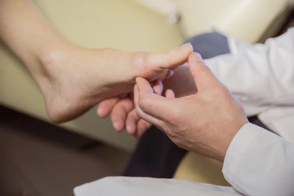 The hands of the doctor examines the foot of a patient — Stock Photo, Image