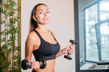 Spor salonunda spor giyim bölümünde güzel bir esmer kadın. Sağlıklı yaşam tarzı.