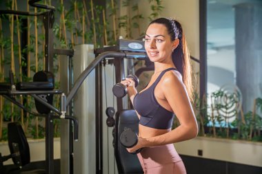 Spor salonunda spor giyim bölümünde güzel bir esmer kadın. Sağlıklı yaşam tarzı.