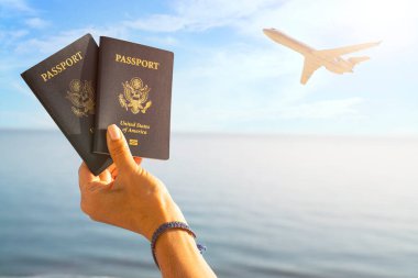 Denizlerin arka planında turizmin sembolü olarak yabancı pasaportlu bir el.