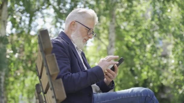 Ein Älterer Rentner Telefoniert Auf Der Straße — Stockvideo