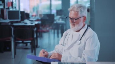 Yaşlı doktor reçete yazıyor. 