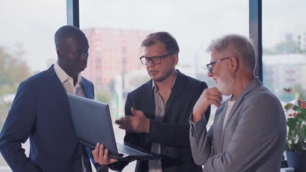 近代的なオフィスに3人のビジネスマン 若い男 アフリカのビジネスマン そして高齢者の上司 — ストック動画