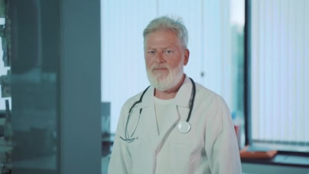 Ein Lächelnder Grauhaariger Alter Arzt — Stockvideo
