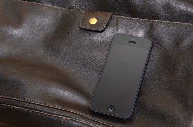 cep telefonu bir deri çanta üzerinde yalan