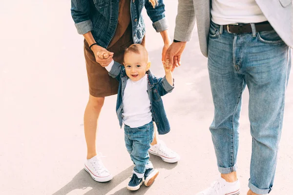 A cute little baby is learning how to walk near his parents — Stock Photo, Image