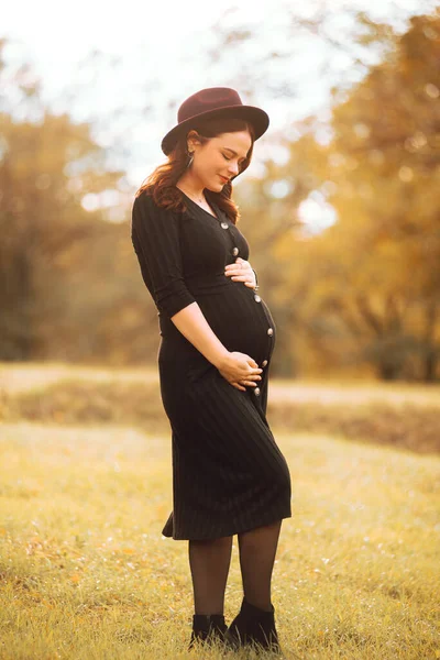 Uma foto uma mulher grávida lindo olhando para sua barriga no parque — Fotografia de Stock