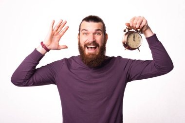 Saati tutan ve heyecanlanan bir adamın fotoğrafı kameraya bakıyor.