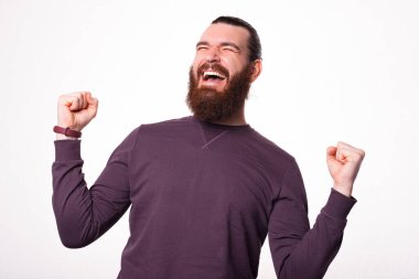 İki eli havada, sakallı bir erkeğin çığlık attığı bir fotoğraf.