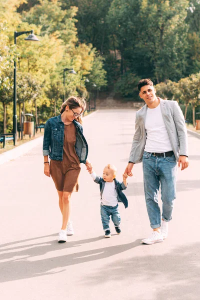 A nice young family is walking in the park with their little baby — Stock Photo, Image