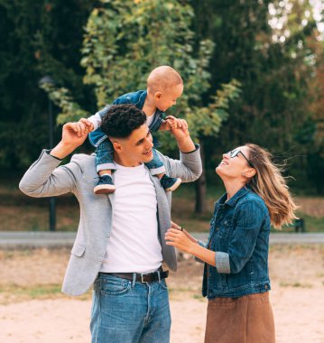 Göz kamaştırıcı genç aile parkta birlikte vakit geçiriyorlar.