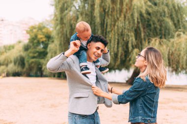 Küçük sevimli bir aile gölün kenarında mutlu.