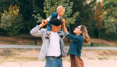 Park 'ta eğlenen küçük şirin bir ailenin fotoğrafı.