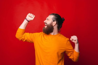 Sakallı bir adam heyecandan çığlık çığlığa bağırıyor.