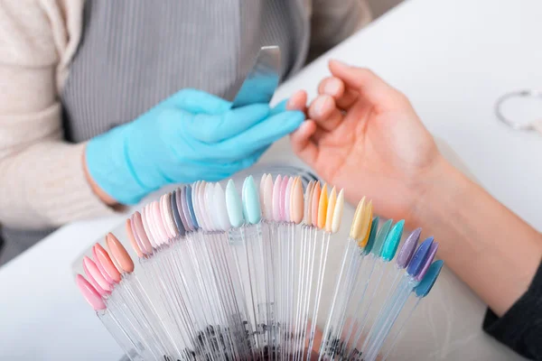 Mulher escolhendo a cor perfeita para suas unhas no salão — Fotografia de Stock