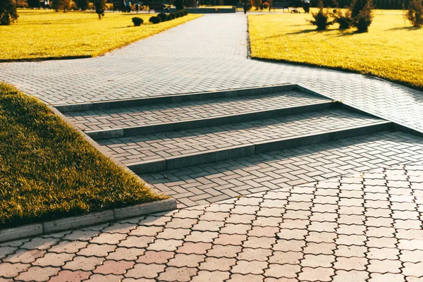 Foto de pavimento fresco y hermoso nuevo y escaleras en el parque durante la puesta del sol — Foto de Stock