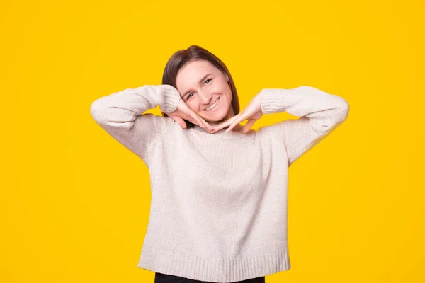 Jovencita sonríe a la cámara con sus manos cerca de su cara — Foto de Stock