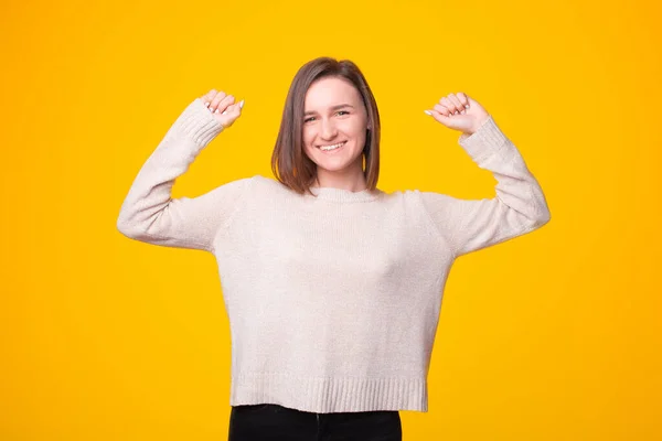 Una mujer excitada está sonriendo a la cámara y sosteniendo sus dos manos arriba — Foto de Stock