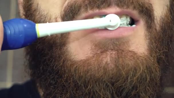 Imágenes de cerca del hombre cepillándose los dientes con cepillo eléctrico — Vídeos de Stock