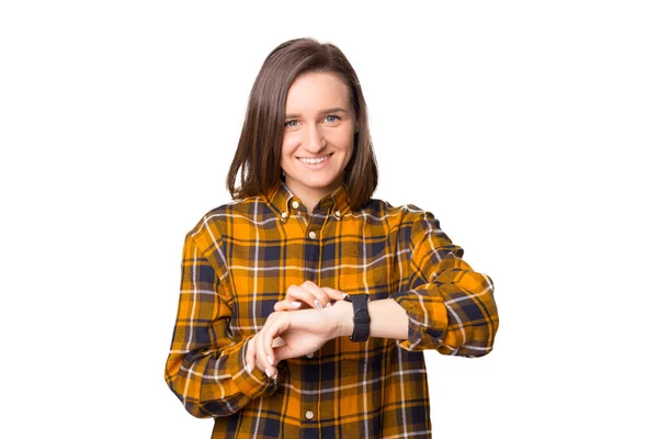 Retrato de una joven sonriente mirando a la cámara y presiona un dedo sobre el reloj inteligente — Foto de Stock