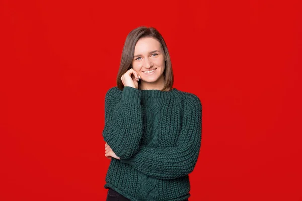 Retrato de una joven sonriente posando frente a la cámara con una sonrisa dentada, de pie sobre un fondo aislado — Foto de Stock