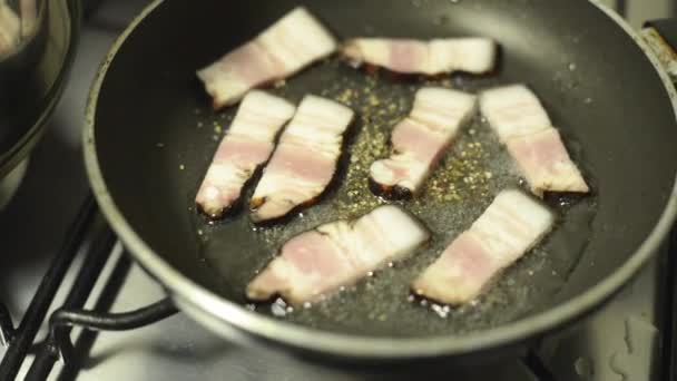 Close up footage of chef preparing bacon in a pan with oil — Stock Video