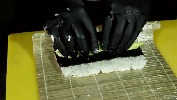 Close-up beelden van sushi meester maken van broodjes met avocado en vis — Stockvideo