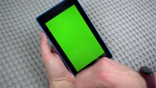 Крупним планом кадри людини, що друкує на планшеті з зеленим екраном — стокове відео