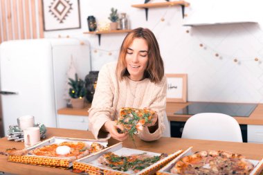 Güzel kadın, mutfağında roka olan pizzayı seçiyor..