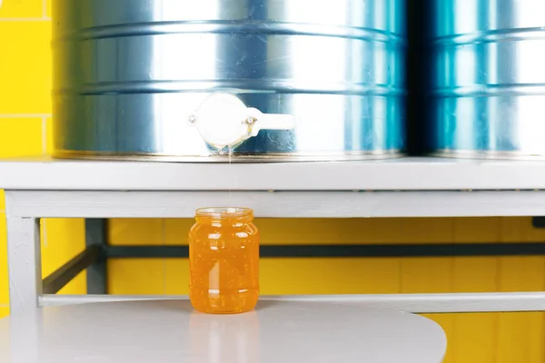 Foto de tarro cerca del tanque de metal de miel en la sección de producción. — Foto de Stock
