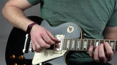 Evde elektro gitar çalan adamın görüntülerini kapat.