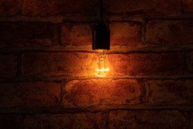 Duvarın üstünde tek bir ampul yanıyor.