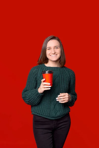 Pionowe zdjęcie młodej damy trzymającej czerwony papier na wynos filiżankę kawy. — Zdjęcie stockowe