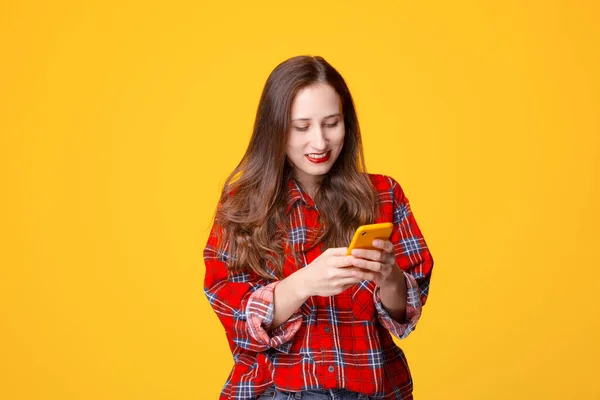 Jovem mulher sorrindo e usando smartphone — Fotografia de Stock