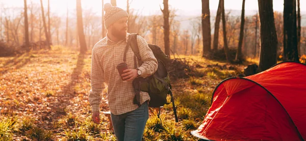 Traveler walking near tent at sunset — Stock Photo, Image