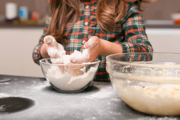 Menina está derramando farinha para massa de uma para outra tigela em casa. — Fotografia de Stock