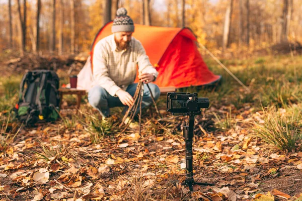 Camera shooting traveler making fire in forest — Stock Photo, Image