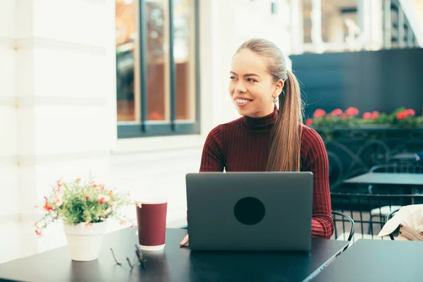 Fjärrarbete, kvinna som sitter på kafé utomhus och arbetar på laptop — Stockfoto