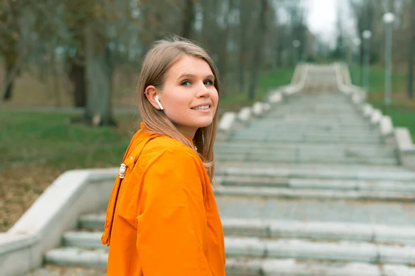 Portret miłej kobiety patrzącej w kamerę w parku gotowej do wejścia po schodach. — Zdjęcie stockowe