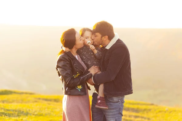 Une belle photo d'une jeune famille debout dans un champ s'amusant — Photo