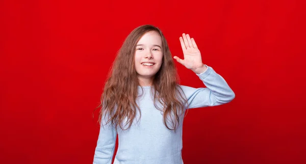 Sorrindo menina dizendo Olá, gesto de saudação sobre fundo vermelho — Fotografia de Stock