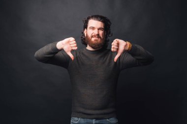 Karanlık arka planda üzgün sakallı bir adamın fotoğrafı.