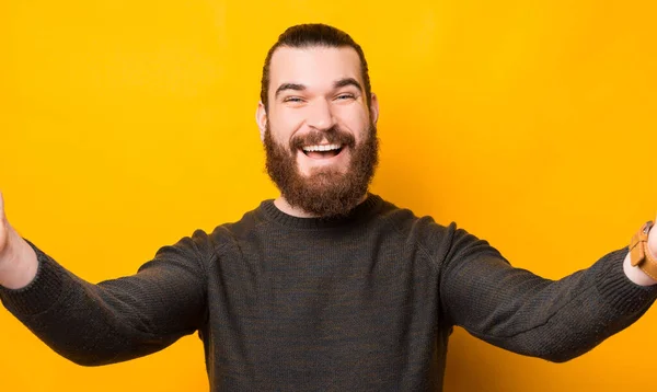 Joyeux homme barbu prenant selfie avec caméra sur fond jaune — Photo