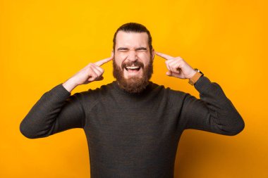 Adamın kulaklarına parmak sokup hiçbir şey dinlemediği bir fotoğraf.