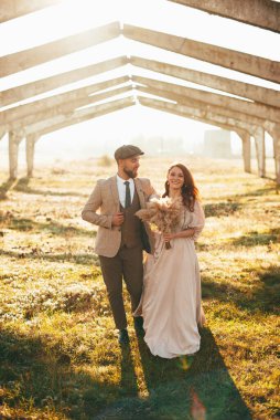 Neşeli, evli bir çift damat ve koca gün batımında birlikte yürüyorlar.